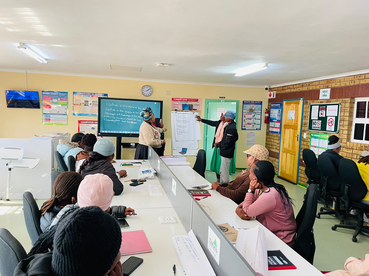 Facilitators guiding learners during an ICDL classroom session at AIT